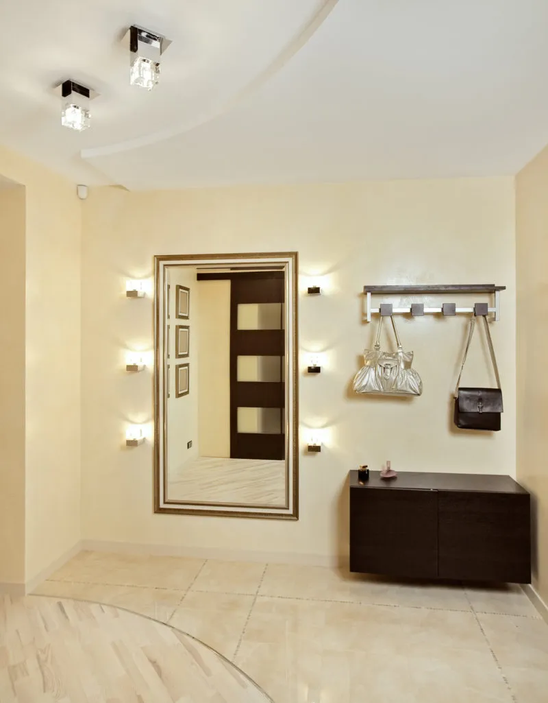 Hall in beige tones with hallstand and golden mirror